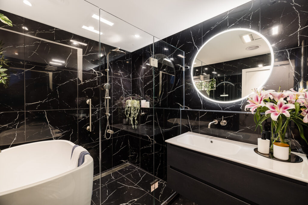 Renovated Bathroom, with black gloss tiles on walls.